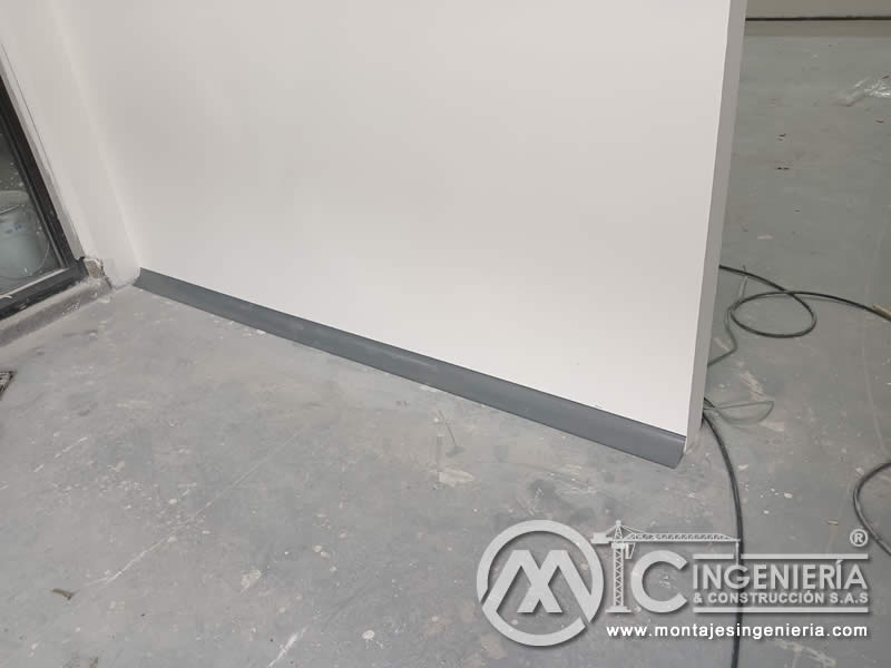 Acabado de guardaescobas en muro de drywall para remodelación comercial en Bogotá, Colombia. Montajes, Ingeniería y Construcción MIC SAS.