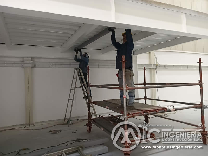 Acabados inferiores de entrepiso metálico con andamios tubulares en Bogotá, Colombia.
