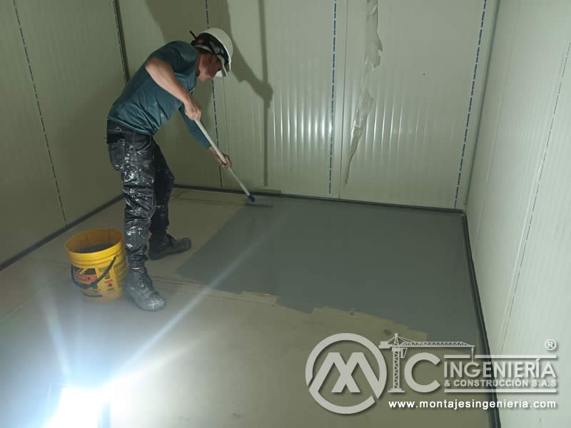 Aplicación de resina epóxica en cuartos fríos con panel sándwich en Bogotá, Colombia. Montajes, Ingeniería y Construcción MIC SAS.