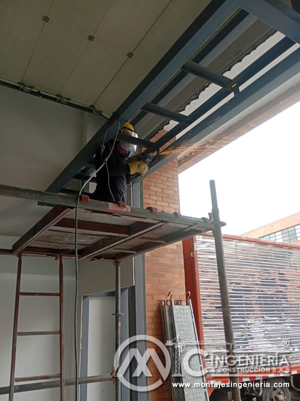Corte y ajuste de estructura metálica para fachada con andamio en local comercial en Bogotá, Colombia. Montajes, Ingeniería y Construcción MIC SAS.