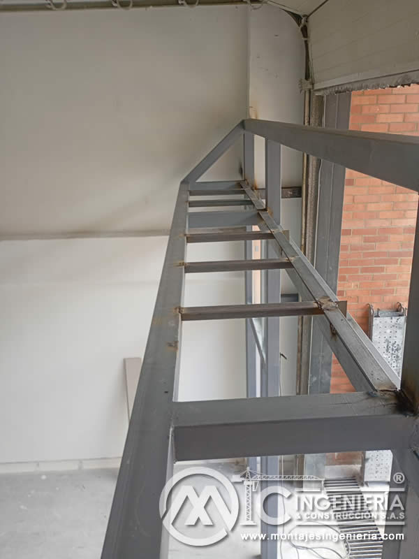 Escalera metálica de acceso a entrepiso pintada en gris para mezzanine en Bogotá, Colombia. Montajes, Ingeniería y Construcción MIC SAS.