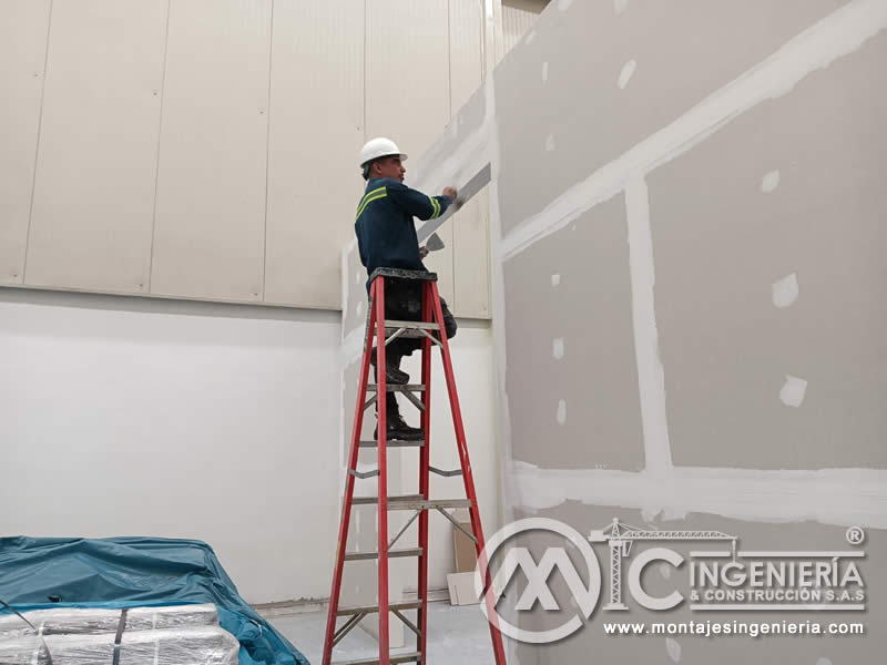 Masillado de juntas en tabiquería de drywall en nave industrial en Bogotá, Colombia. Montajes, Ingeniería y Construcción MIC SAS.