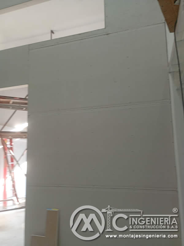 Muro de drywall terminado con vano de puerta en bodega industrial en Bogotá, Colombia. Montajes, Ingeniería y Construcción MIC SAS.