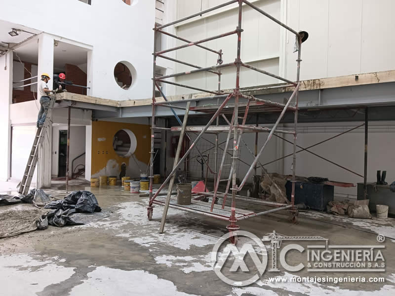 Operarios en acabados de mezzanine metálico en local industrial en Bogotá, Colombia.
