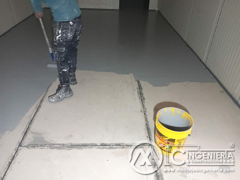 Aplicación con rodillo de pintura epóxica para pisos de cámara frigorífica en Bogotá, Colombia. Montajes, Ingeniería y Construcción MIC SAS.