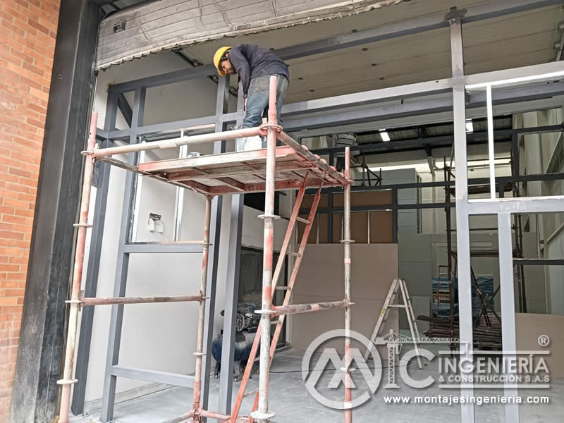 Soldadura de marco metálico en fachada de local comercial en Bogotá, Colombia.