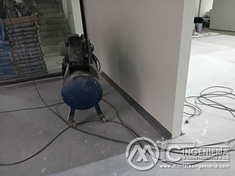 Uso de compresor en adecuación de muros en drywall para locales comerciales en Bogotá, Colombia. Montajes, Ingeniería y Construcción MIC SAS.