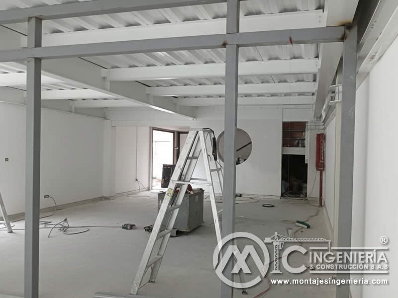 Vista inferior de estructura metálica de mezzanine con deck en nave industrial en Bogotá, Colombia. Montajes, Ingeniería y Construcción MIC SAS.