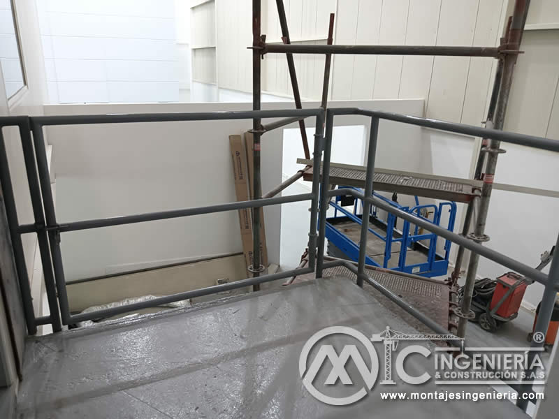 Barandilla tubular en mezanine de local comercial con andamio de trabajo en Bogotá, Colombia. Montajes, Ingeniería y Construcción MIC SAS.