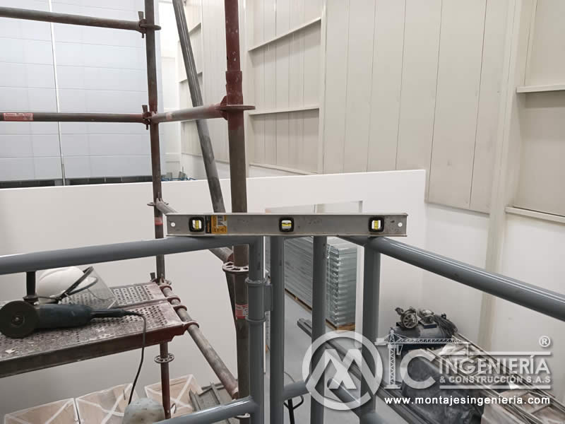 Control de nivel en instalación de barandilla para mezanine de local en Bogotá, Colombia. Montajes, Ingeniería y Construcción MIC SAS.