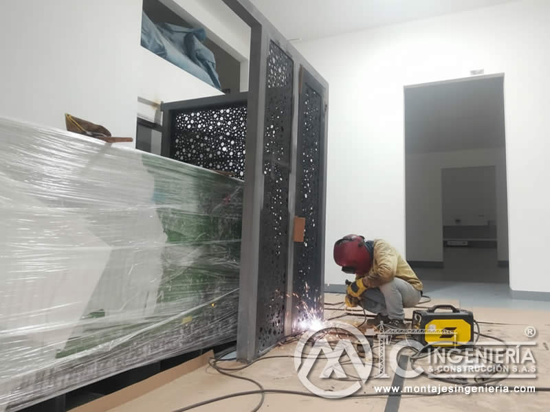 Corte y soldadura en obra de paneles metálicos perforados decorativos en Bogotá, Colombia. Montajes, Ingeniería y Construcción MIC SAS.