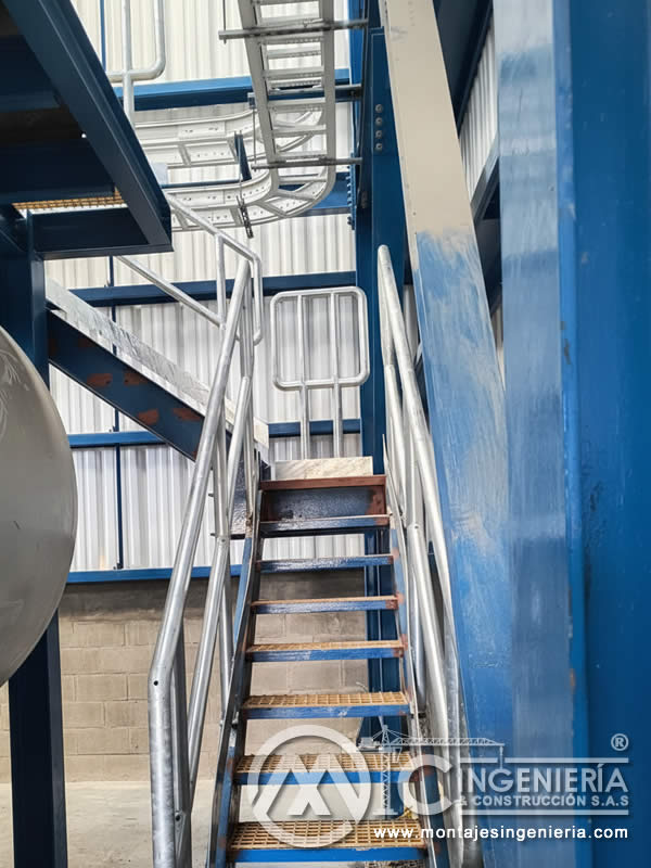 Escalera metálica galvanizada con peldaños en rejilla para bodegas e industria en Bogotá, Colombia. Montajes, Ingeniería y Construcción MIC SAS.