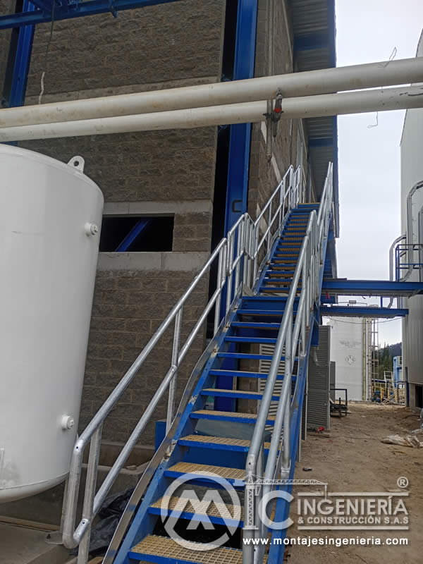 Escalera metálica industrial con barandilla y piso en rejilla para plantas en Bogotá, Colombia. Montajes, Ingeniería y Construcción MIC SAS.