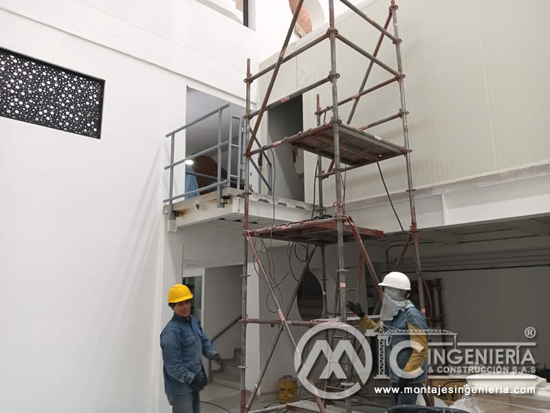 Montaje de mezanine con barandilla y panel perforado en locales comerciales en Bogotá, Colombia. Montajes, Ingeniería y Construcción MIC SAS.