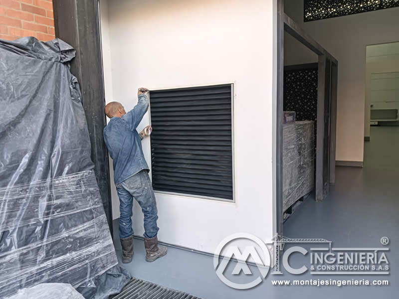 Montaje de rejillas metálicas con lamas en fachadas de locales comerciales en Bogotá, Colombia. Montajes, Ingeniería y Construcción MIC SAS.