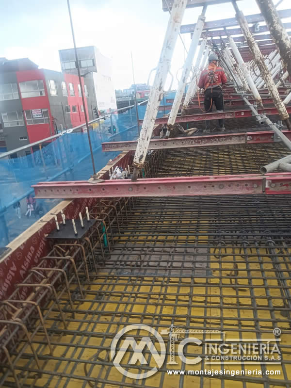 Operario con arnés de seguridad en losa de refuerzo para puente vehicular en Bogotá, Colombia. Montajes, Ingeniería y Construcción MIC SAS.