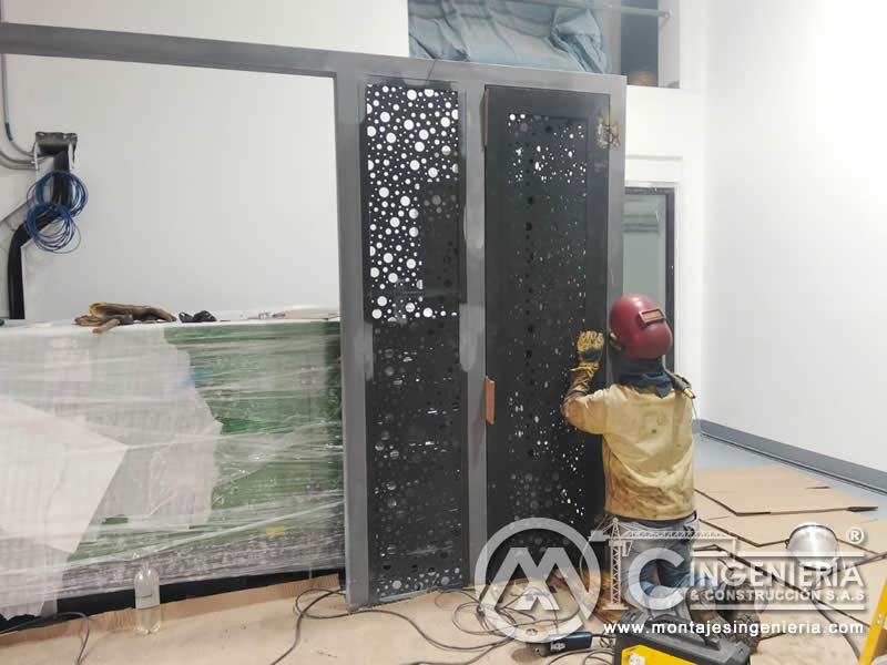 Soldadura de puertas metálicas con lámina perforada decorativa en Bogotá, Colombia. Montajes, Ingeniería y Construcción MIC SAS.