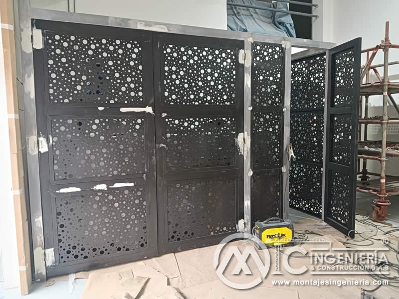 Instalación de portones abatibles con lámina perforada decorativa para locales comerciales en Bogotá, Colombia. Montajes, Ingeniería y Construcción MIC SAS.