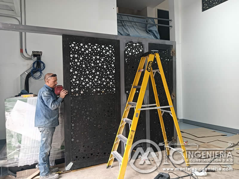 Instalación de puerta metálica con lámina perforada decorativa para locales y bodegas en Bogotá, Colombia. Montajes, Ingeniería y Construcción MIC SAS.
