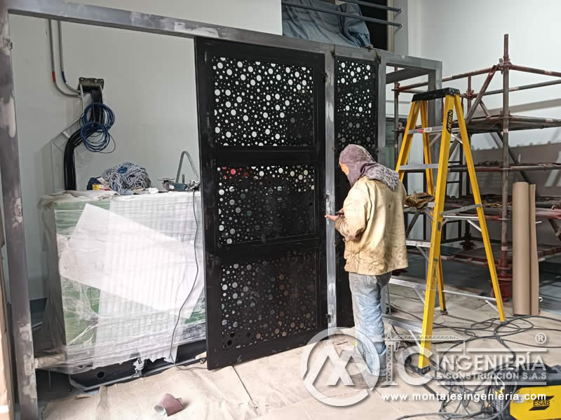 Instalación y ajuste de puerta metálica perforada individual en local comercial en Bogotá, Colombia. Montajes, Ingeniería y Construcción MIC SAS.