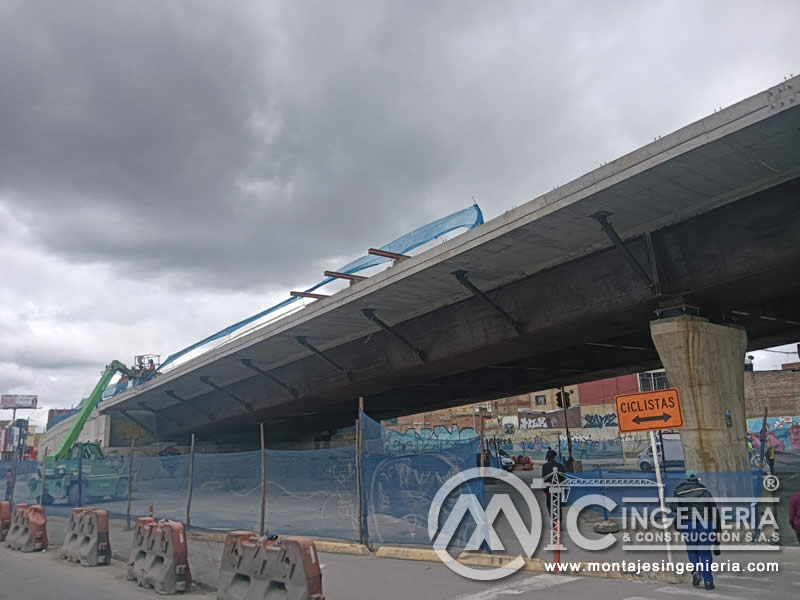 Montaje de estructura metálica en puente vial urbano con grúa y andamios en Bogotá, Colombia. Montajes, Ingeniería y Construcción MIC SAS.