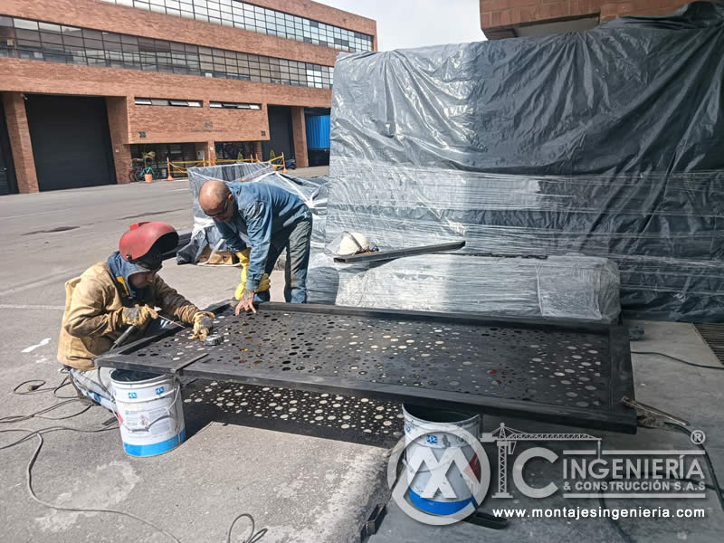 Aplicación de pintura anticorrosiva en paneles metálicos perforados decorativos para portones en Bogotá, Colombia. Montajes, Ingeniería y Construcción MIC SAS.
