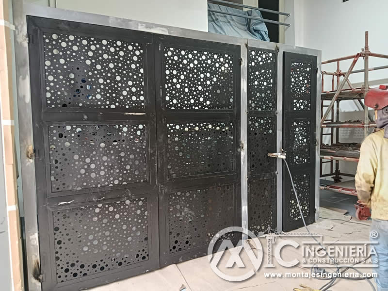 Portones de lámina perforada en negro mate instalados para accesos de locales comerciales en Bogotá, Colombia. Montajes, Ingeniería y Construcción MIC SAS.
