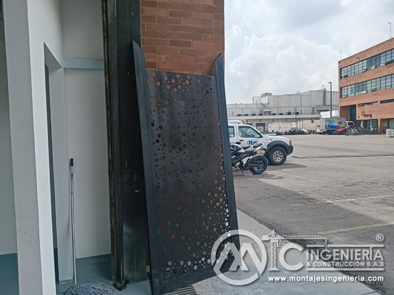 Puerta metálica con lámina perforada decorativa lista para instalación en local comercial en Bogotá, Colombia. Montajes, Ingeniería y Construcción MIC SAS.