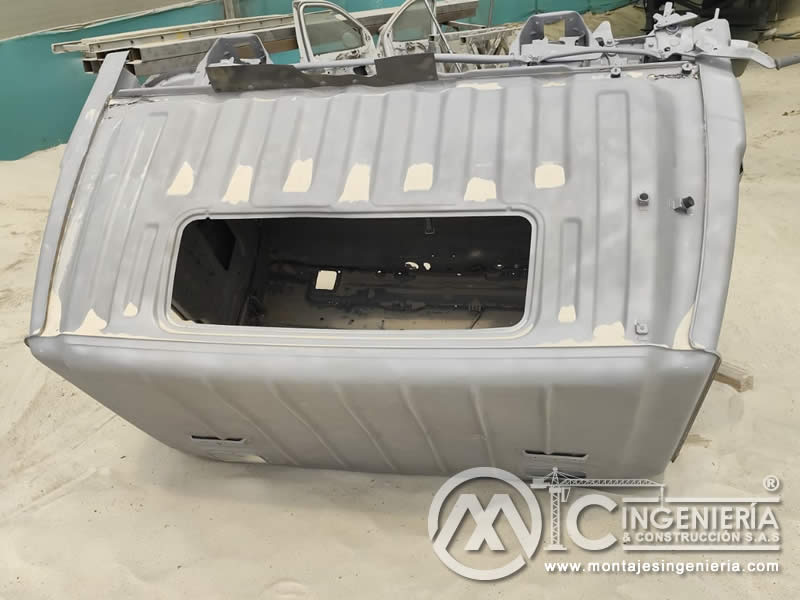 Sandblasting y aplicación de pintura de fondo en carrocería de vehículo industrial en Bogotá, Colombia. Montajes, Ingeniería y Construcción MIC SAS.