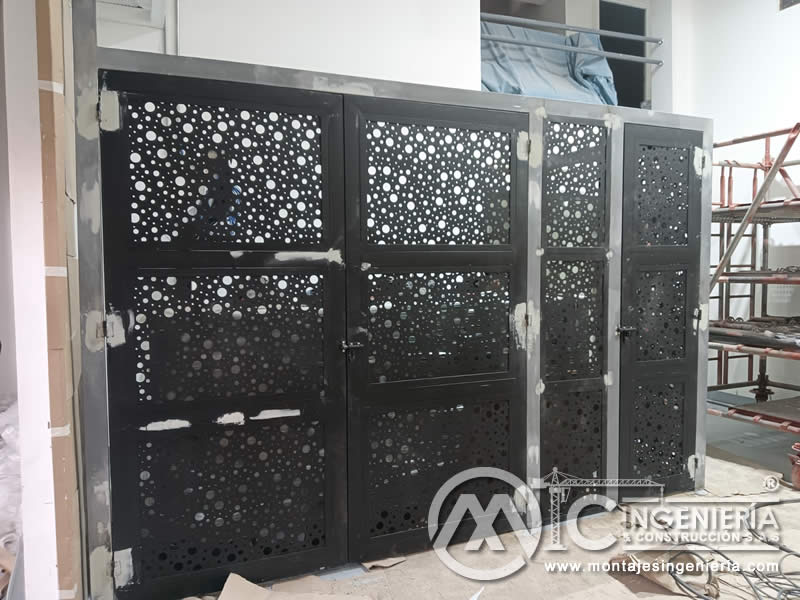 Sistema de portones decorativos metálicos con lámina perforada instalados en locales comerciales en Bogotá, Colombia. Montajes, Ingeniería y Construcción MIC SAS.