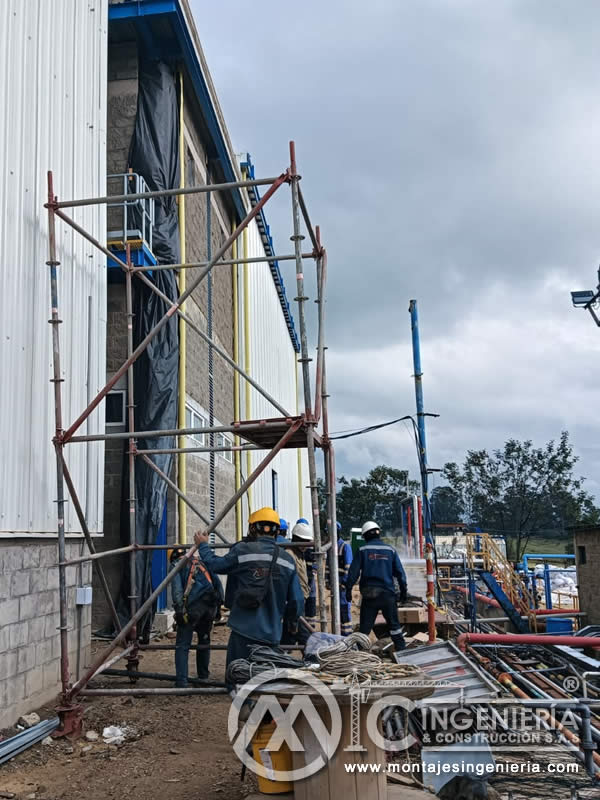 Cuadrilla de montaje con andamio en fachada de planta industrial en Bogotá, Colombia. Montajes, Ingeniería y Construcción MIC SAS.