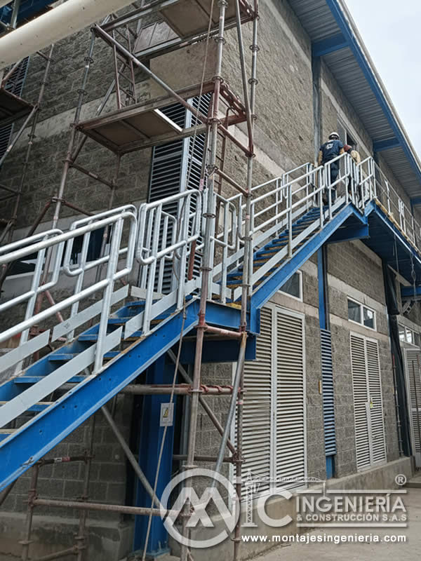 Escalera metálica azul con descanso y barandas para planta industrial en Bogotá, Colombia. Montajes, Ingeniería y Construcción MIC SAS.