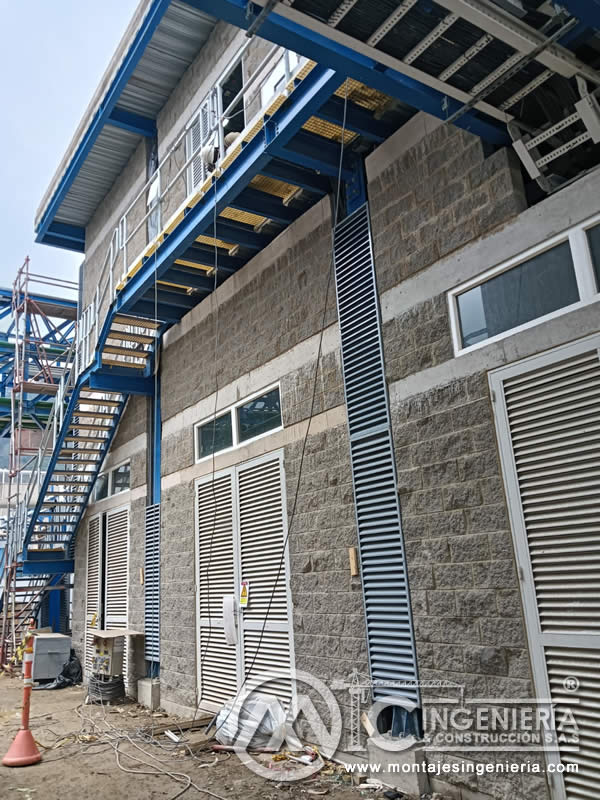 Fachada industrial con louvers, plataforma metálica y escalera azul en Bogotá, Colombia. Montajes, Ingeniería y Construcción MIC SAS.