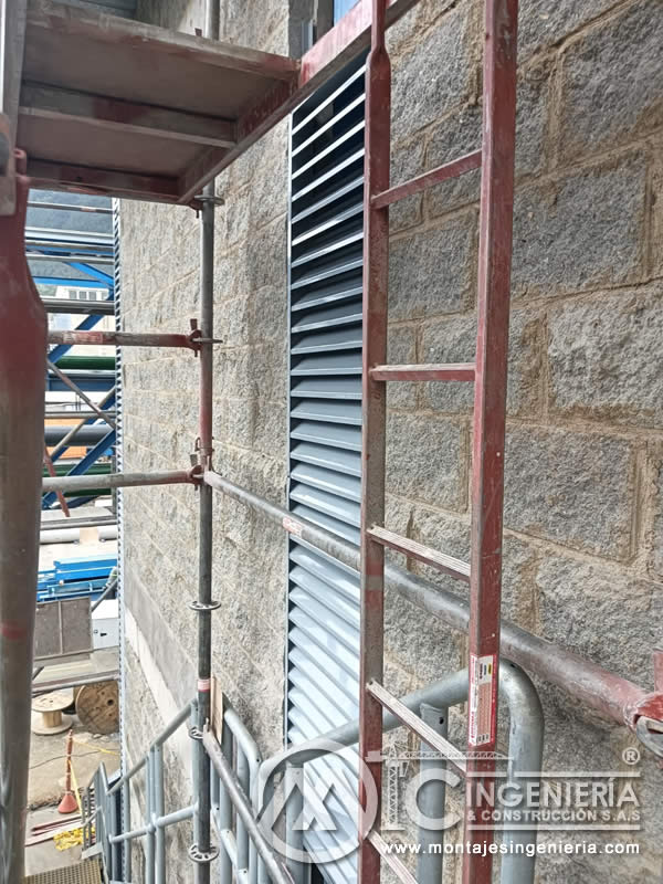 Instalación de louver metálico en fachada con andamio tubular en Bogotá, Colombia. Montajes, Ingeniería y Construcción MIC SAS.