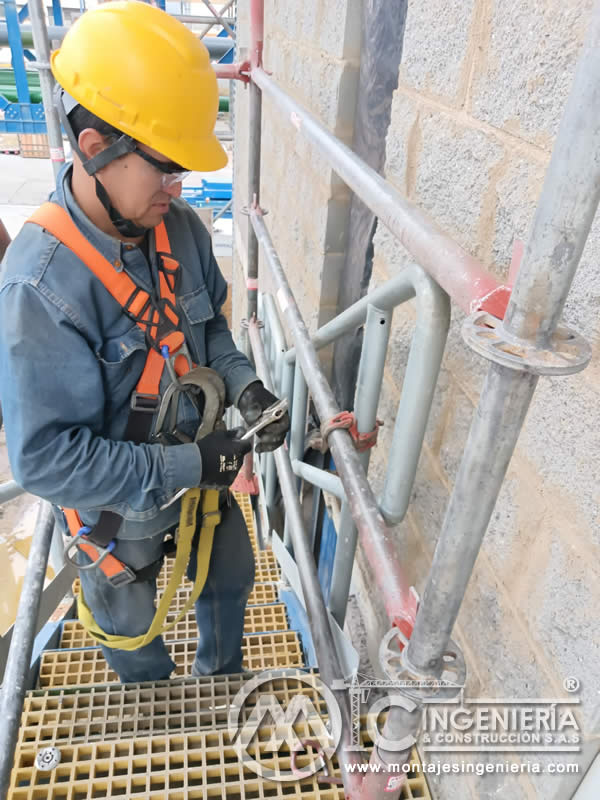 Operario con arnés ajustando andamio en plataforma FRP industrial en Bogotá, Colombia. Montajes, Ingeniería y Construcción MIC SAS.