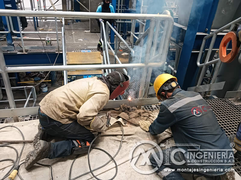 Soldadores en montaje de barandas y plataformas industriales en Bogotá, Colombia. Montajes, Ingeniería y Construcción MIC SAS.