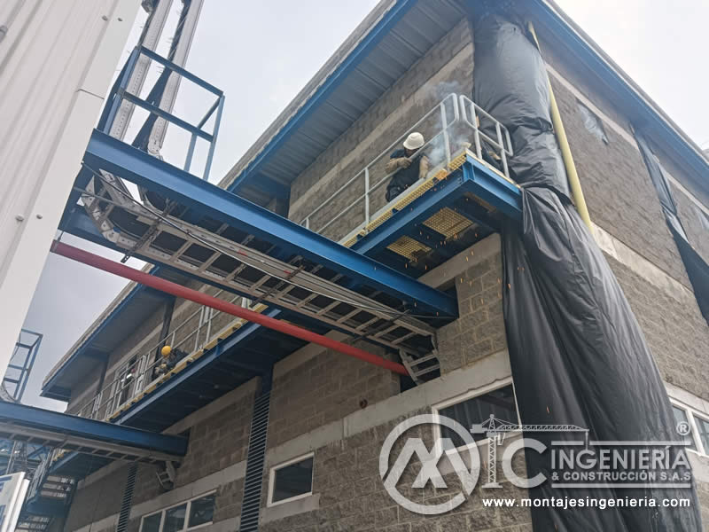 Trabajo en altura en plataforma metálica elevada en planta industrial en Bogotá, Colombia. Montajes, Ingeniería y Construcción MIC SAS.