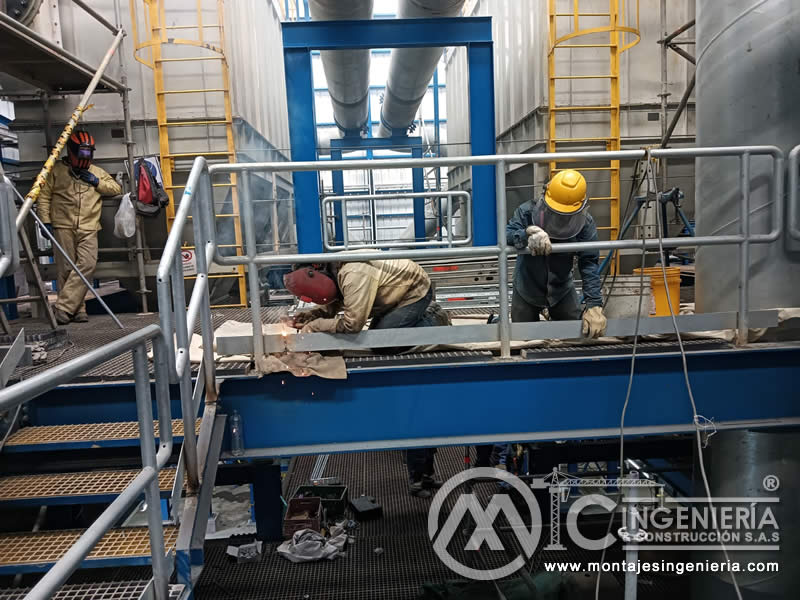 Trabajos de soldadura en plataforma con rejilla FRP en planta industrial en Bogotá, Colombia. Montajes, Ingeniería y Construcción MIC SAS.