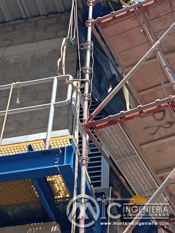 Detalle de plataforma metálica azul con rejilla y escalera industrial en Bogotá, Colombia. Montajes, Ingeniería y Construcción MIC SAS.