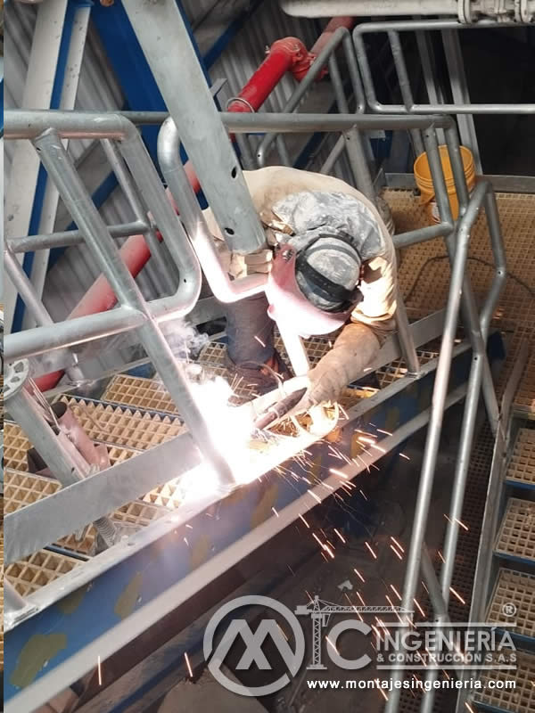 Soldadura de barandas metálicas en plataformas con rejilla fiberglass en Bogotá, Colombia. Montajes, Ingeniería y Construcción MIC SAS.
