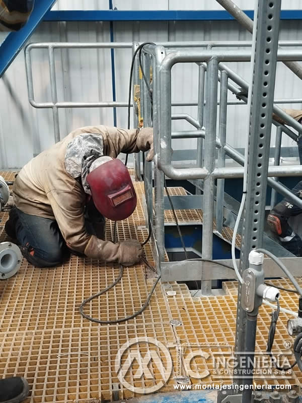 Soldadura de barandas y escaleras en plataformas con rejilla industrial en Bogotá, Colombia. Montajes, Ingeniería y Construcción MIC SAS.
