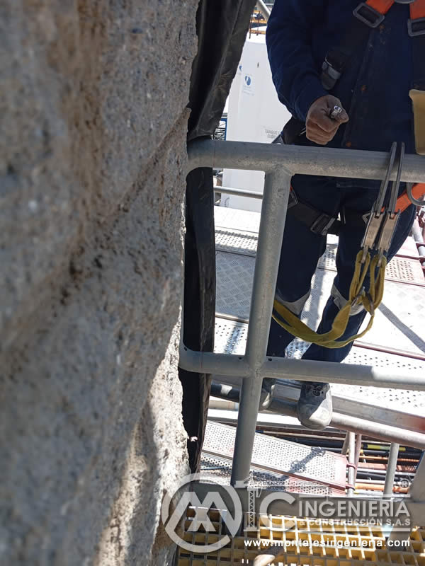 Trabajo en altura con arnés en plataformas de fachadas industriales en Bogotá, Colombia. Montajes, Ingeniería y Construcción MIC SAS.
