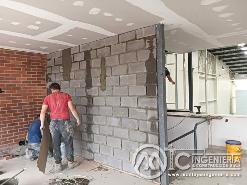Construcción de divisiones en bloque de concreto con estructura metálica liviana en adecuación de interiores en Bogotá, Colombia. Montajes, Ingeniería y Construcción MIC SAS.