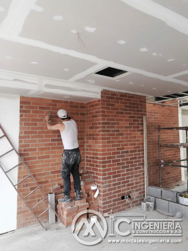 Construcción de muros de ladrillo con cielo raso en drywall en Bogotá, Colombia. Montajes, Ingeniería y Construcción MIC SAS.