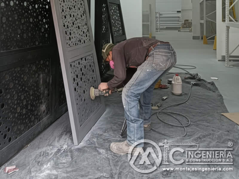 Esmerilado y preparación superficial de puertas metálicas con lámina perforada antes de pintura en Bogotá, Colombia. Montajes, Ingeniería y Construcción MIC SAS.