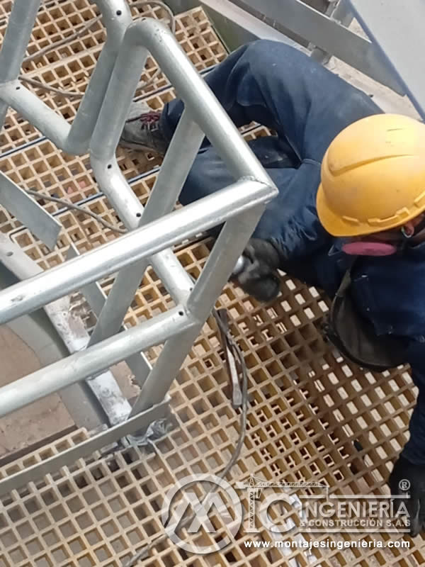 Fijación de pasamanos tubular galvanizado en plataforma con piso de rejilla para instalaciones industriales en Bogotá, Colombia. Montajes, Ingeniería y Construcción MIC SAS.
