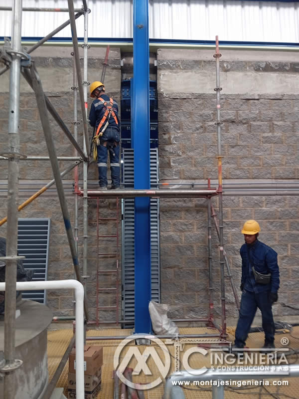 Instalación de elevador vertical con personal en altura y andamios en planta industrial en Bogotá, Colombia. Montajes, Ingeniería y Construcción MIC SAS.