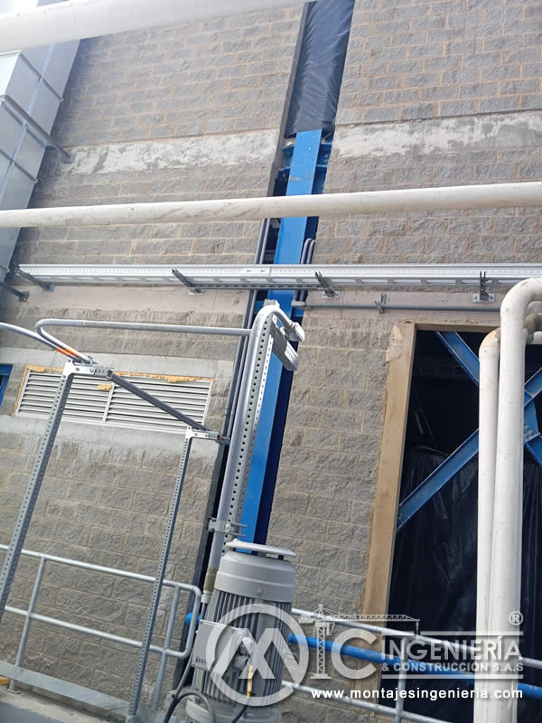 Montaje de elevador de cangilones con estructura metálica y tubería industrial en planta de producción en Bogotá, Colombia. Montajes, Ingeniería y Construcción MIC SAS.