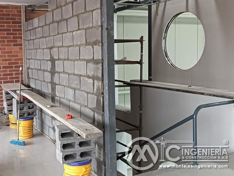 Muro en bloque de concreto con ventana circular en estructura metálica para proyecto de adecuación en Bogotá, Colombia. Montajes, Ingeniería y Construcción MIC SAS.