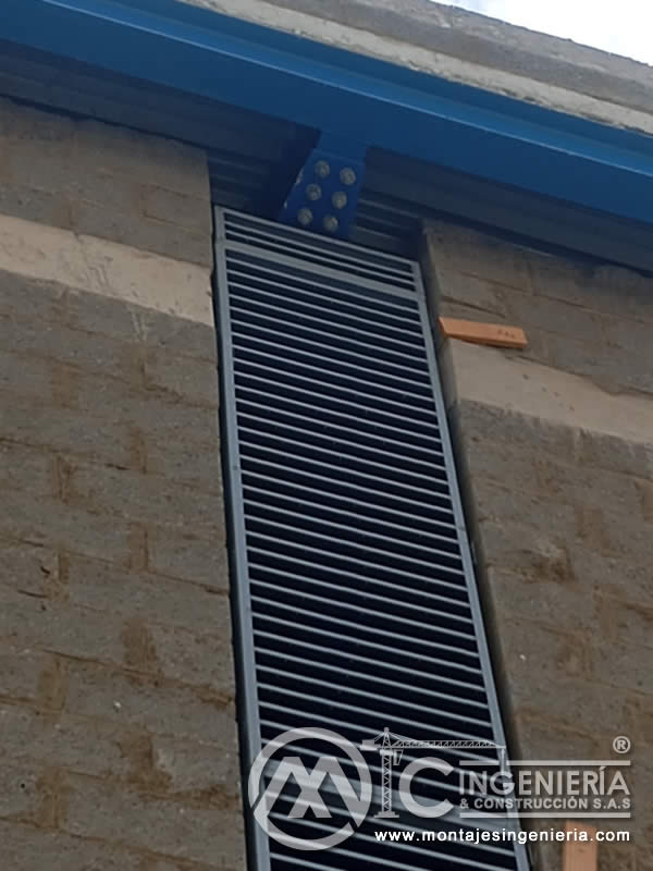 Panel de lamas metálicas instalado en fachada de planta industrial en Bogotá, Colombia. Montajes, Ingeniería y Construcción MIC SAS.